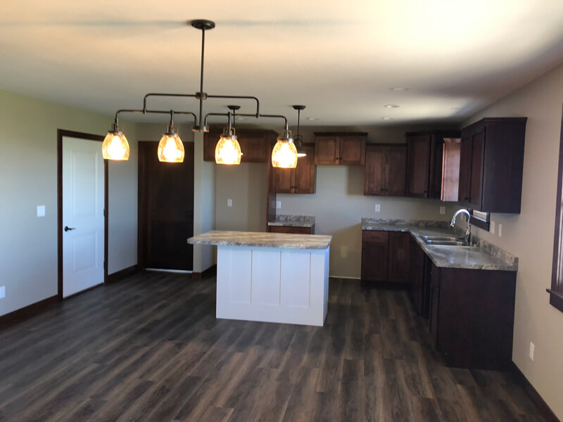 A kitchen with wood floors and white cabinets.