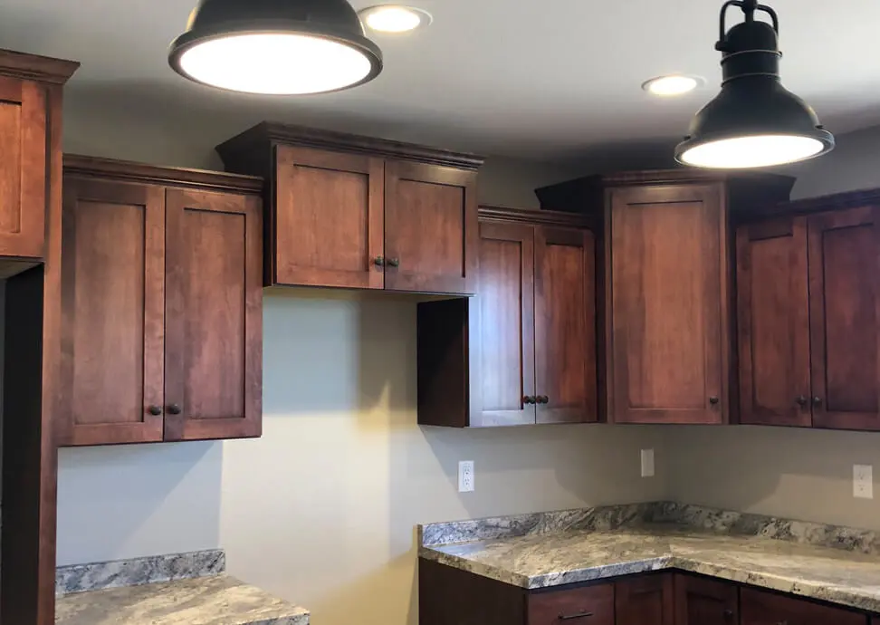 A kitchen with wooden cabinets and granite counter tops.